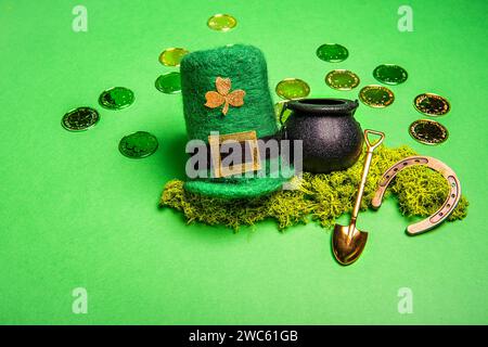 Goldmünzen verstreut auf grünem isoliertem Hintergrund, St. Patricks Hut, Kobold Kessel, Schaufel, Hufeisen für viel Glück. Grußkarte für traditionell Stockfoto