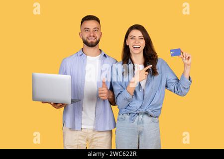 Glückliches Paar mit Laptop und Kreditkarte, Online-Shopping erfolgreich Stockfoto