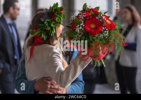 Fröhlicher Absolvent der Universität Genua mit traditionellem Lorbeerkranz und rotem Band und Blumenstrauß, Genua, Italien Stockfoto