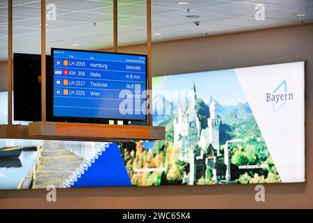 Arrival sign for Lufthansa and Star Alliance partners at the baggage carousel in Terminal 2 with advertising poster for Bavaria with Neuschwanstein Stockfoto