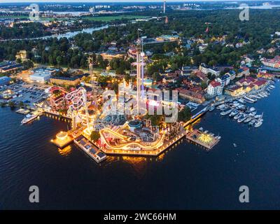 Der Vergnügungspark Grona Lund in Stockholm am Abend, mit hellen Lichtern, einem laufenden Konzert und dem Meer in der Nähe. Stockfoto