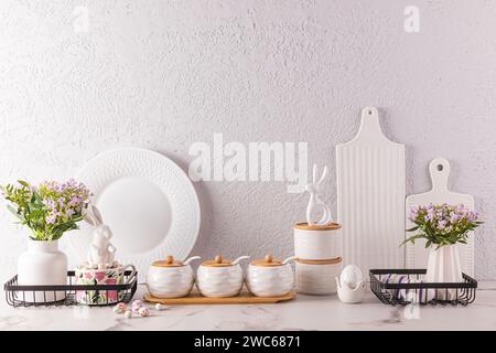 Stilvoller Küchen-Hintergrund für Osterferien mit traditionellen Symbolen und weißem Geschirr. Vordergrund. Osterferienkonzept Stockfoto