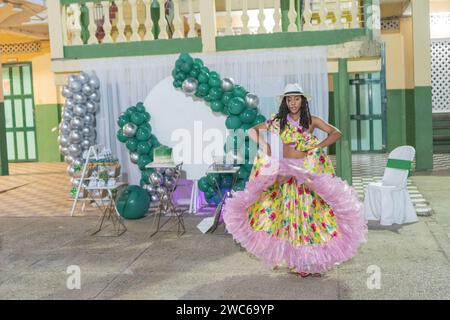 Die junge Frau tanzt Cumbia, ihr Blumenrock weht Stockfoto