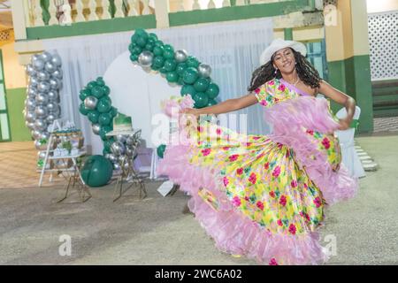 Lateinische Frau tanzt Cumbia, ihr Blumenrock weht Stockfoto
