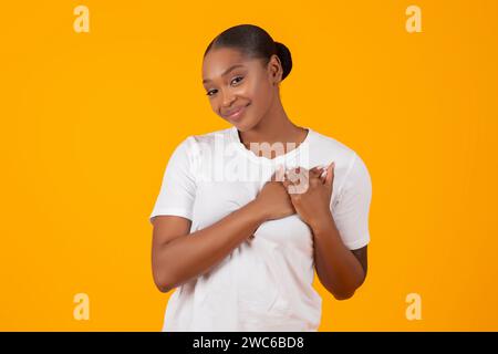Dankbare Afroamerikanische Junge Dame, Die Hände Auf Die Brust Drückt, Studio Stockfoto