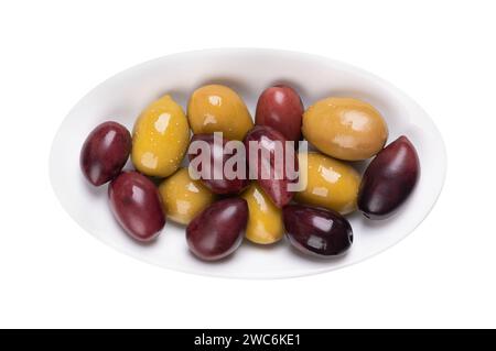 Kalamata und grüne Oliven mit Grube, ganz eingelegt, große griechische Tafeloliven, in einer weißen ovalen Schüssel. Stockfoto