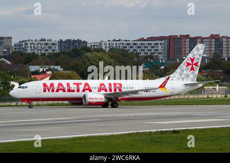 Die Malta Air Boeing 737 MAX 8-200 der Billigfluggesellschaft Ryanair fährt nach der Landung auf dem Flughafen Lemberg mit der Stadt im Hintergrund Stockfoto