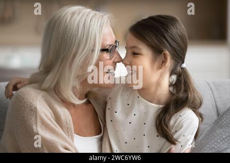 Glückliche Seniorengroßmutter und süßer Enkel, der sich umarmt, lacht und Freizeit genießt Stockfoto