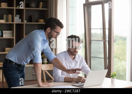 Zwei Zwillingsbrüder arbeiten zusammen im Homeoffice Stockfoto