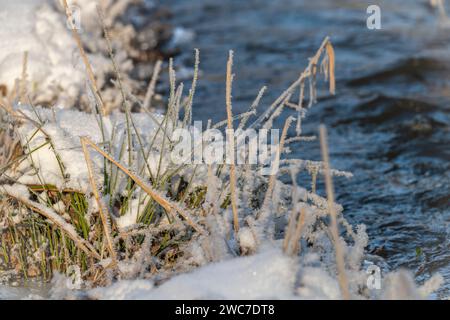 Schneebedeckter kalter Bach Kysela voda in der Nähe eines großen Dorfes an sonnigem Tag Stockfoto