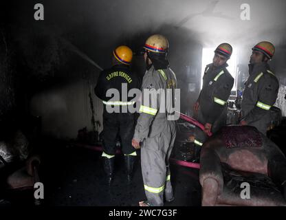 Noida, Indien. Januar 2024. NOIDA, INDIEN – 14. JANUAR: Ein Team von Feuerwehrleuten, die versuchen, ein Feuer zu löschen, entkernt in einem Haus und rettete drei Menschen in Sektor 25, am 14. Januar 2024 in Noida, Indien. Vier Fahrzeuge der Feuerwehr brachten den Brand nach etwa einer Stunde Einsatzzeit unter Kontrolle. (Foto: Sunil Ghosh/Hindustan Times/SIPA USA) Credit: SIPA USA/Alamy Live News Stockfoto