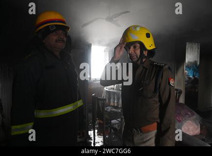 Noida, Indien. Januar 2024. NOIDA, INDIEN – 14. JANUAR: Ein Team von Feuerwehrleuten, die versuchen, ein Feuer zu löschen, entkernt in einem Haus und rettete drei Menschen in Sektor 25, am 14. Januar 2024 in Noida, Indien. Vier Fahrzeuge der Feuerwehr brachten den Brand nach etwa einer Stunde Einsatzzeit unter Kontrolle. (Foto: Sunil Ghosh/Hindustan Times/SIPA USA) Credit: SIPA USA/Alamy Live News Stockfoto