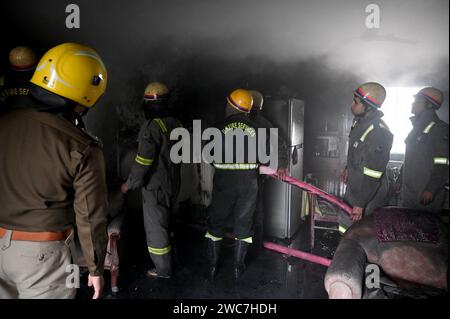 Noida, Indien. Januar 2024. NOIDA, INDIEN – 14. JANUAR: Ein Team von Feuerwehrleuten, die versuchen, ein Feuer zu löschen, entkernt in einem Haus und rettete drei Menschen in Sektor 25, am 14. Januar 2024 in Noida, Indien. Vier Fahrzeuge der Feuerwehr brachten den Brand nach etwa einer Stunde Einsatzzeit unter Kontrolle. (Foto: Sunil Ghosh/Hindustan Times/SIPA USA) Credit: SIPA USA/Alamy Live News Stockfoto