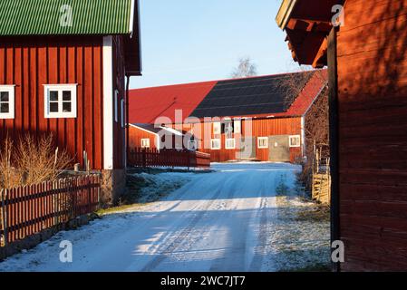 Dorfgasse in Einem schwedischen Dorf in Småland im Winter zur Weihnachtszeit mit typischen roten Holzhäusern Stockfoto