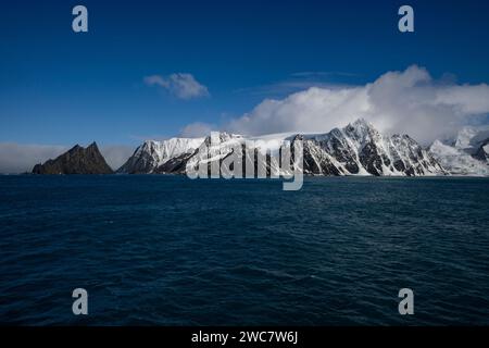 Elephant Island felsiges Ufer und hohe schneebedeckte Gipfel, Sternzeichen nähern sich der Küste, Rowett Island und Cape Lookout, steil aufragende Klippen aus dem Ozean Stockfoto