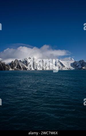 Elephant Island felsiges Ufer und hohe schneebedeckte Gipfel, Sternzeichen nähern sich der Küste, Rowett Island und Cape Lookout, steil aufragende Klippen aus dem Ozean Stockfoto