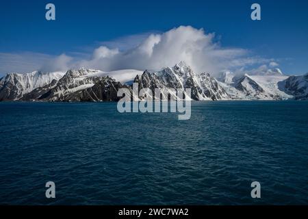 Elephant Island felsiges Ufer und hohe schneebedeckte Gipfel, Sternzeichen nähern sich der Küste, Rowett Island und Cape Lookout, steil aufragende Klippen aus dem Ozean Stockfoto