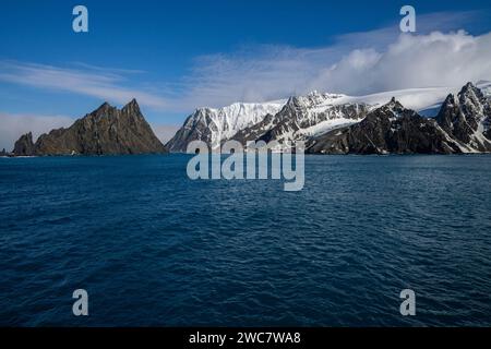 Elephant Island felsiges Ufer und hohe schneebedeckte Gipfel, Sternzeichen nähern sich der Küste, Rowett Island und Cape Lookout, steil aufragende Klippen aus dem Ozean Stockfoto