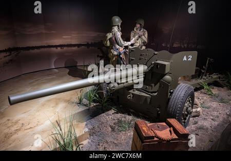 Zwei Soldaten sprechen. Detail eines Bataillons amerikanischer Luftsoldaten hinter einem 6-Pfünder-Typ M1 57 mm leichten Panzerabwehrgewehr bei Nacht. Stockfoto