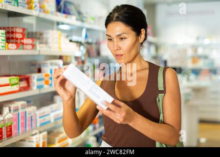Frau, die Medikamente in der Drogerie wählt Stockfoto