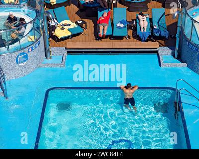 Südpazifik Kreuzfahrt / Kreuzfahrtpassagiere entspannen sich in einem Whirlpool und Pool auf dem Deck der Carnival Pracht. Nach der Abfahrt von Sydney Stockfoto