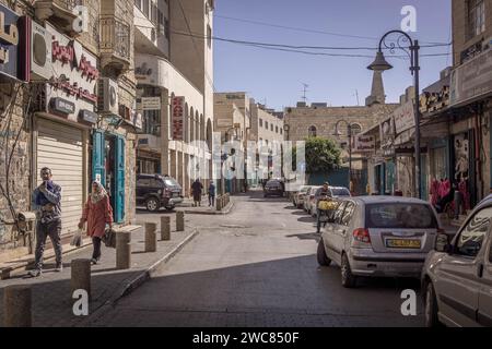 Die Straßen von Bethlehem, Westjordanland, Palästina, mit Autos, Gebäuden, Händlerläden, Verkehr und lokale Palästinenser, die vorbeikommen. Stockfoto