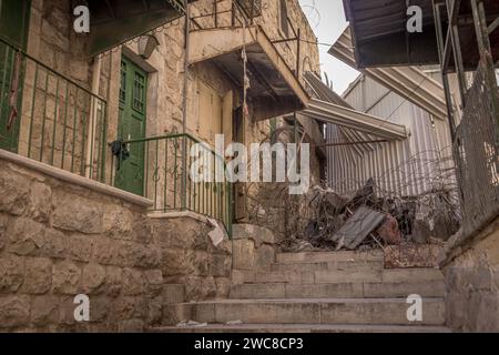 Der Stacheldraht und die blockierte Passage an der Grenze zwischen israelisch kontrollierten und von Palästina kontrollierten Gebieten Hebrons im palästinensischen Westjordanland. Stockfoto