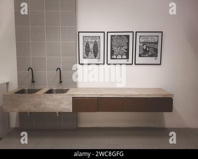 Ein wunderschönes Waschbecken mit drei Bildern an der weißen Wand Stockfoto