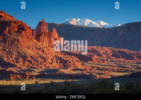 Fisher Towers leuchtet am späten Nachmittag im Licht der schneebedeckten La Sal Mountains als Kulisse Stockfoto