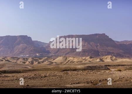 Der Blick auf das Felsplateau mit dem Masada-Nationalpark darüber, der sich am felsigen Rand der Judäischen Wüste im Osten Israels befindet Stockfoto