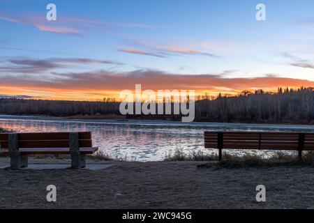 Stadt Edmonton Fort Edmonton Fußgängerparklandschaft mit zwei Bänken mit Blick auf den Sonnenuntergang am Fluss in der späten Herbstsaison und Eis Stockfoto