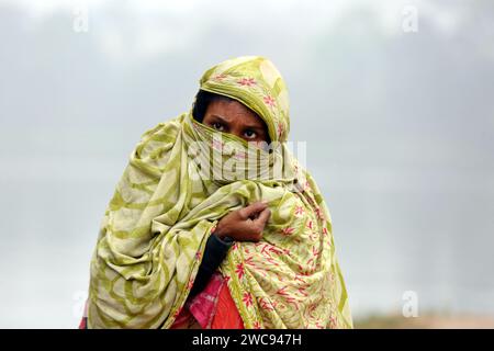 Dhaka, Bangladesch. Januar 2024. Menschen reisen am 13. Januar 2023 an ihren Arbeitsplatz während Eines nebeligen Wintertags in Dhaka, Bangladesch. Bangladesch Hat Seine Niedrigste Temperatur Bei 8,8 Grad In Dinajpur Verzeichnet. Die Kälte, die spät in dieser Saison eintraf, hat endlich fest eingelebt. Sonnenlicht ist aufgrund von Nebel in verschiedenen Teilen des Landes knapp, und die Menschen leiden unter der schweren Kälte. Foto: Habibur Rahman/ABACAPRESS.COM Credit: Abaca Press/Alamy Live News Stockfoto