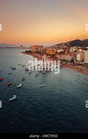 Los Muertos Beach Pier mit Booten, die in der Bucht sitzen und auf die romantische Zone von Puerto Vallarta Mexiko blicken. Stockfoto