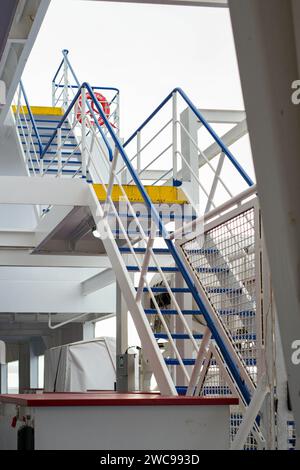 Vertikale Aufnahme einer komplexen Industrietreppe in Blau und weiß. Das Bild zeigt das komplizierte Design der Struktur, ausgestattet mit sa Stockfoto