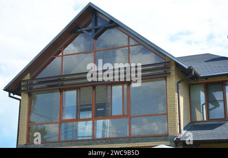 Moderne Dachkonstruktion mit Dachrinne und Panoramablick-Mansarde, Dachfenster. Dachgeschoss Glaswand. Stockfoto