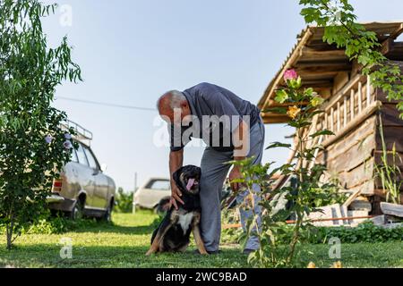 Ein Mann und sein liebenswerter, flauschiger Hund posieren. Stockfoto