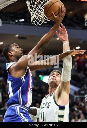 Milwaukee, USA. Januar 2024. Harrison Barnes (L) fährt im NBA-Saisonspiel in Milwaukee (USA) am 14. Januar 2024 gegen den Milwaukee Bucks Center Brook Lopez in den Korb. Quelle: Joel Lerner/Xinhua/Alamy Live News Stockfoto