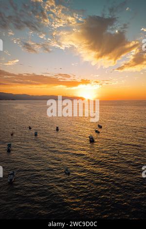 Vertikale idyllische Aussicht auf den Sonnenuntergang aus der Vogelperspektive in der Nähe des Los Muertos Beach Pier am Himmel und der Boote in der Bucht. Stockfoto