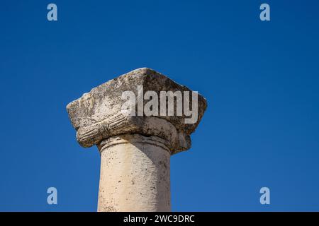 Eine alte Steinsäule vor einem blauen wolkenlosen Himmel in der alten griechischen Stadt Heraclea Lyncestis in der Nähe des heutigen Bitola in Nordmazedonien. Stockfoto