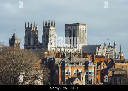 Blick auf das historische York Minster von den Dächern des Stadtzentrums von York, von den alten Stadtmauern aus gesehen. An einem bewölkten Tag mit Sonne. Stockfoto