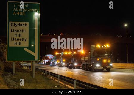 Hirwaun Power, Drax, transportierte ein 700 Tonnen schweres Lastkraftfahrzeug zusammen mit einer Polizeieskorte auf der A456 in der Nähe von Llanelli Hill als Teil der Arbeiten zum Bau eines neuen Gaskraftwerks, des Kraftwerks, das einmal in Betrieb war, kann bis zu 1.500 Stunden in einem beliebigen Jahr laufen. Es wird Unterstützung für andere Stromquellen bereitstellen, einschließlich wetterabhängiger Windturbinen und Solarparks, Llanelli Hill, Vereinigtes Königreich, 15. Januar 2024 Link to Hirwaun Power; https://www.drax.com/about-us/our-projects/hirwaun-power/#frequently-asked-questions-faqs (Foto: Thomas Winstone/News Images) Stockfoto