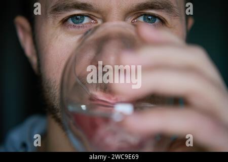 Mann trinkt Wasser, Nahaufnahme des bärtigen Mannes, der frisches sauberes Wasser aus Glas trinkt, Durst löschen, Lebensstil Gesundheitskonzept Stockfoto