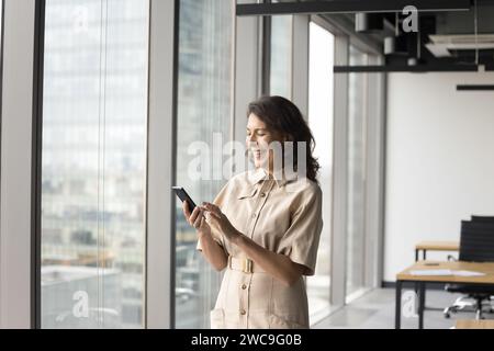 Glückliche, reife Geschäftsinhaberin, die die Internet-App nutzt Stockfoto