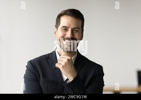 Fröhlicher, gutaussehender Geschäftsmann, der in die Kamera schaut Stockfoto
