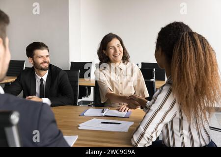 Junge afrikanische Geschäftsfrau, die der Kollegin die Hand schüttelt Stockfoto