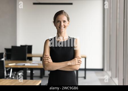 Glückliche junge Geschäftsführerin, die im Amt steht Stockfoto