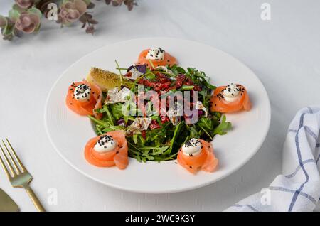 Salat mit Lachs, Rucola und sonnengetrockneten Tomaten, frischem Salat Stockfoto