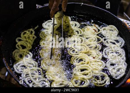 indisches traditionelles süßes Jalebi-Frittieren in heißem raffiniertem Öl Stockfoto