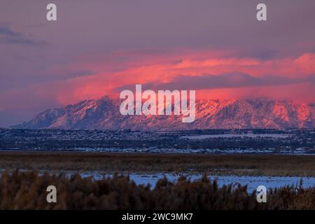 Das Nachglühen der untergehenden Sonne wirft ein rosafarbenes Licht auf die Wolken und den Berg Ben Lomond. Auf der Nordseite von Ogden, Weber County, Utah, USA. Stockfoto