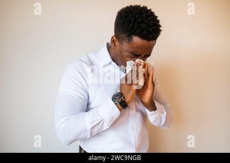 Porträt eines jungen Geschäftsmannes, der Allergie hat und Nase bläst. Kopieren Sie einen Platz auf dem Bild für Ihren Text oder Ihre Werbung. Stockfoto